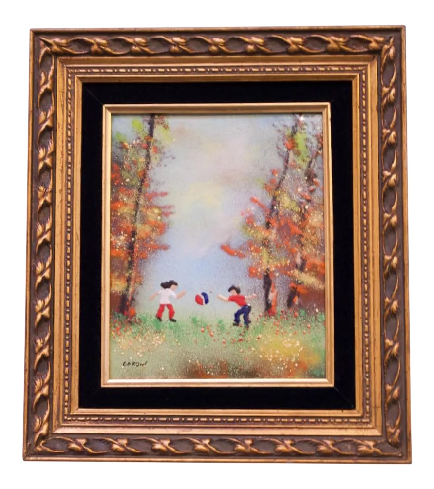 French Enamel on Copper Painting by Louis Cardin: Enamel on Copper painting by renowned French enamelist, Louis Cardin (b. 1931 France), depicting a young boy and girl playing with a ball in a forest. Lined in black velvet housed in a giltwood