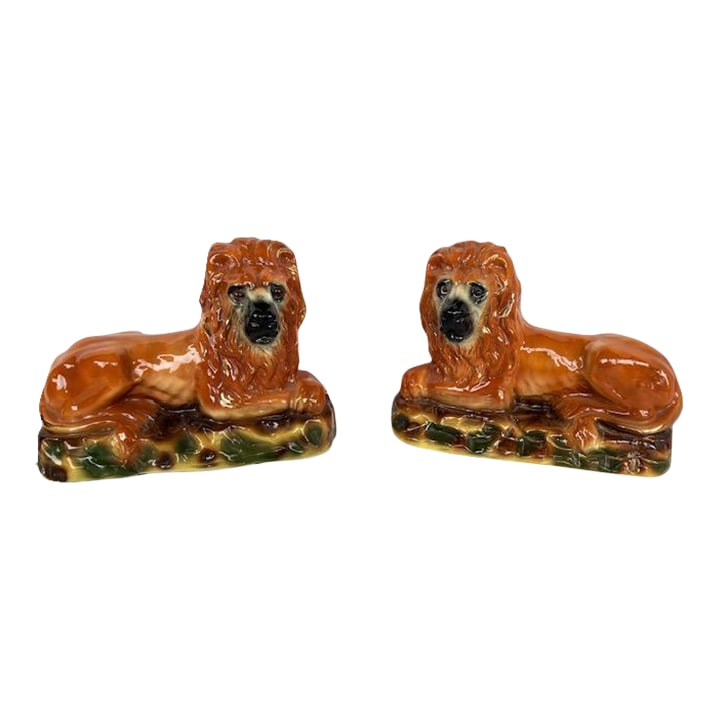 Staffordshire Lions With Glass Eyes: Large pair of Staffordshire Lions with glass eyes in brilliant colors Early 1900's. Both pieces have firing holes in the bottoms and one has a small crack in the bottom which has been secured upon