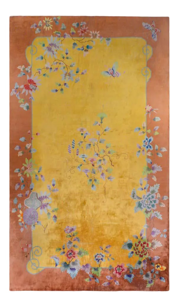 Chinese Art Deco Rug: A wonderful early 20th century Chinese Art Deco rug with a bright gold field surrounded by a wide orange border, both overlaid with multicolored lotus and peonies, and butterflies. Condition: Alterati