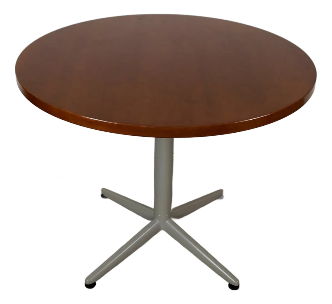 1990's Vintage Herman Miller Style Round Dining Table: Vintage Midcentury Modern style dining table for sale. Has a pedestal metal star base in a gray finish, and a cherry wood top. The top has a light cherry finish that contrasts nice with the gray base.