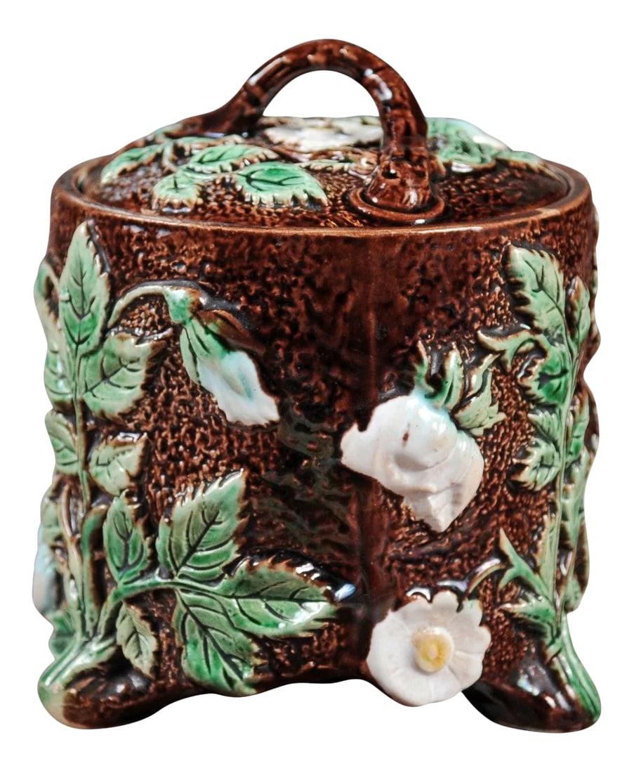 French 19th Century Brown Majolica Lidded Jar with Moulded Floral Décor: A French brown Majolica lidded jar from the 19th century with green and white moulded floral décor. Born in France during the 19th century, this Majolica jar boasts a lovely brown ground adorned