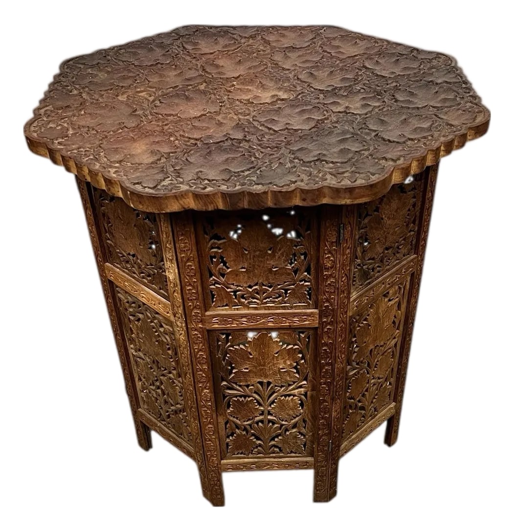 Vintage Anglo Indian Rare Pattern Heavily Carved Teak Octagonal Table: Vintage rare pattern and shape Anglo Indian heavily hand carved teak octagonal folding table. The octagonal top is hand carved of grape leaves and grapes while the paneled bottom is carved leaves.