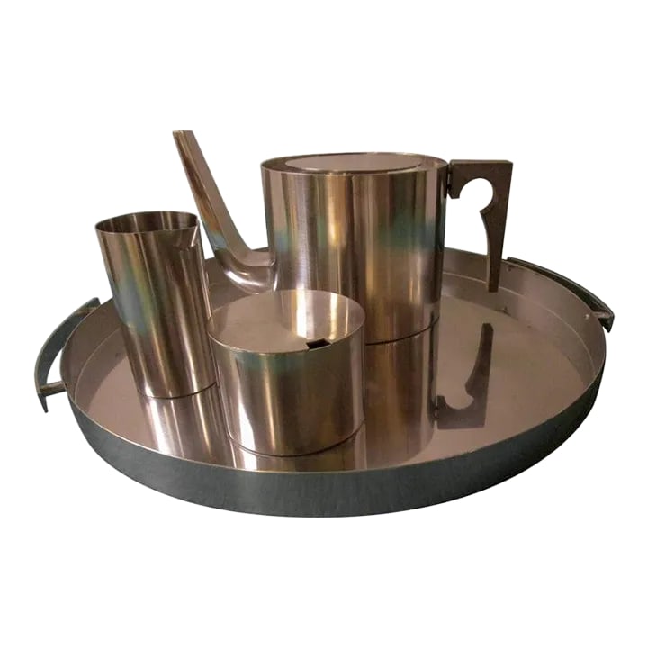 Mid-Century Modern Stainless Steel Tea Service by Arne Jacobsen for Stelton: This four piece Classic Mid-Century Modern stainless steel tea set is by Arne Jacobsen for Stelton, Denmark. The set includes a tray with handles, a lidded tea pot with a wooden handle, a creamer and 