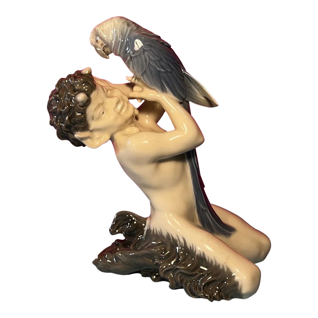 Royal Copenhagen Porcelain Figurine Pan/Faun With a Parrot # 752: This exquisite Royal Copenhagen Porcelain Figurine features a mythical scene of a young faun and his parrot. Crafted with meticulous attention to detail by skilled artisans from the renowned Royal