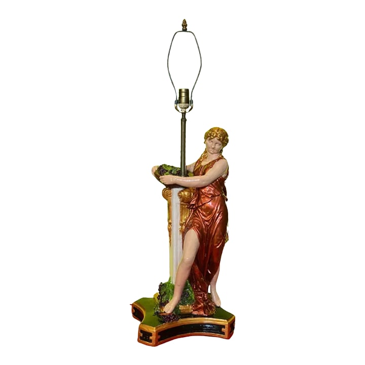 Mid-Century Grecian Women With Basket of Grapes Table Lamp: This exquisite Mid-Century chalkware table lamp is a masterful blend of artistry and elegance, showcasing a neoclassical theme. The figure of a Greek woman, draped in a diaphanous red gown that