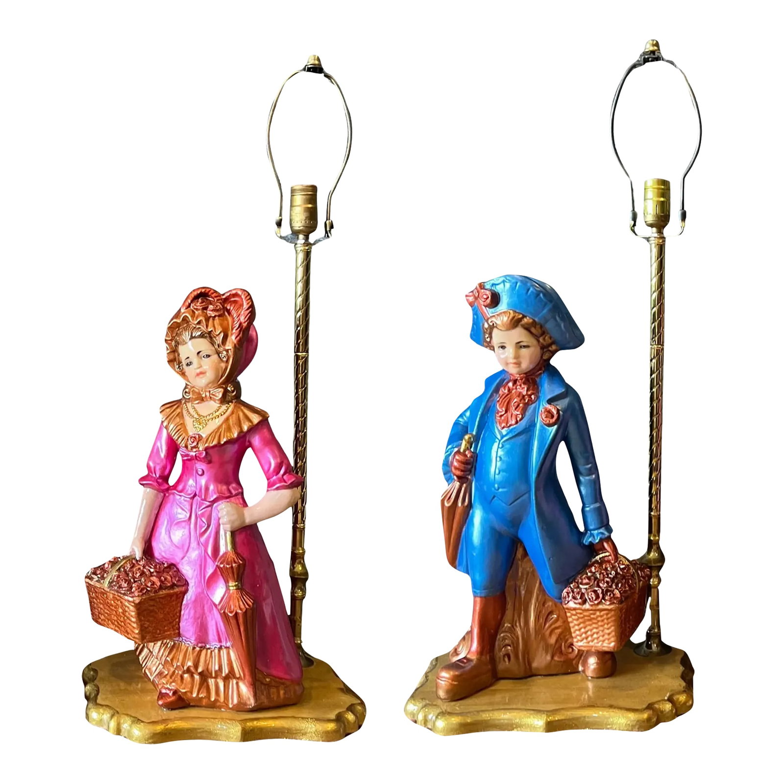Mid-Century Chalkware Figural Boy and Girl Carrying Flower Baskets Table Lamp -A Pair: These impressive chalkware sculptures feature a charming Victorian-era boy and girl, each elegantly posed with finely detailed attire and accessories. The figures are adorned in period-accurate clothi