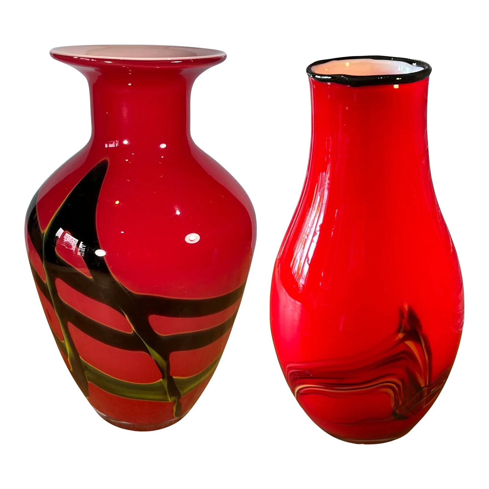 Art Glass Red Abstract Vases- A Pair: These two hand-blown abstract red glass vases, each with cased white glass interiors, are striking examples of artistry in glasswork. While they share a common foundation—their vibrant red hue