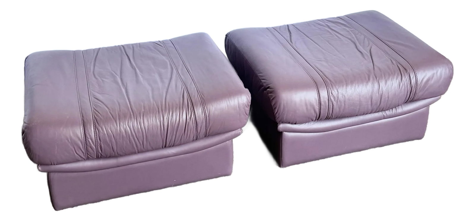 Vintage Italian Purple Leather Ottomans on Castors - A Pair: Soft, sculptural, and undeniably chic—this pair of vintage Italian ottomans brings a luxurious pop of postmodern color in rich purple leather. Plush, pillowy tops rest on streamlined bases with