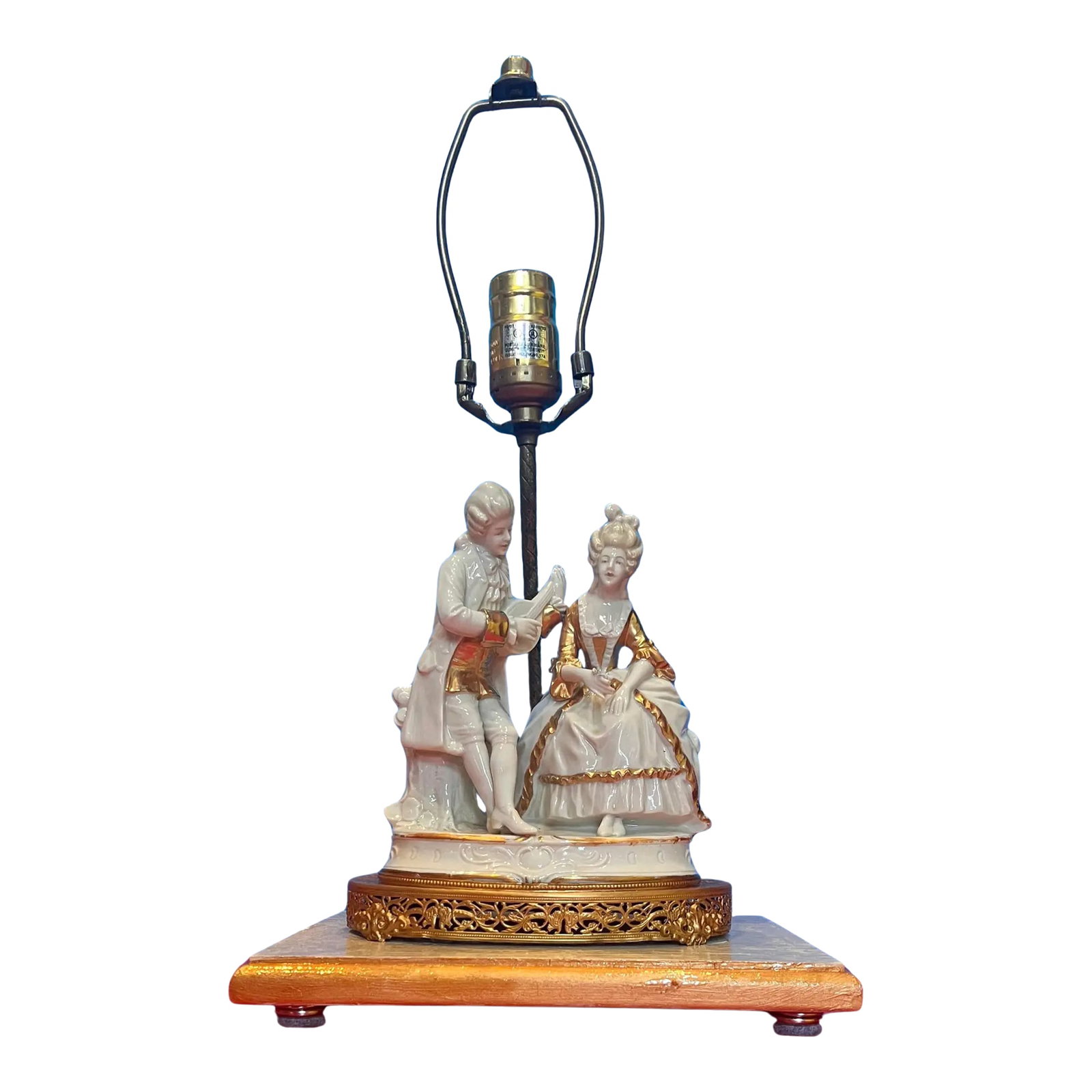 Mid-Century Porcelain Figural Table Lamp Courting Couple: This porcelain lamp stands as a testament to delicate artistry and refined craftsmanship. At its base, two figures intricately detailed in white porcelain and dressed in lavish 18th-century attireR
