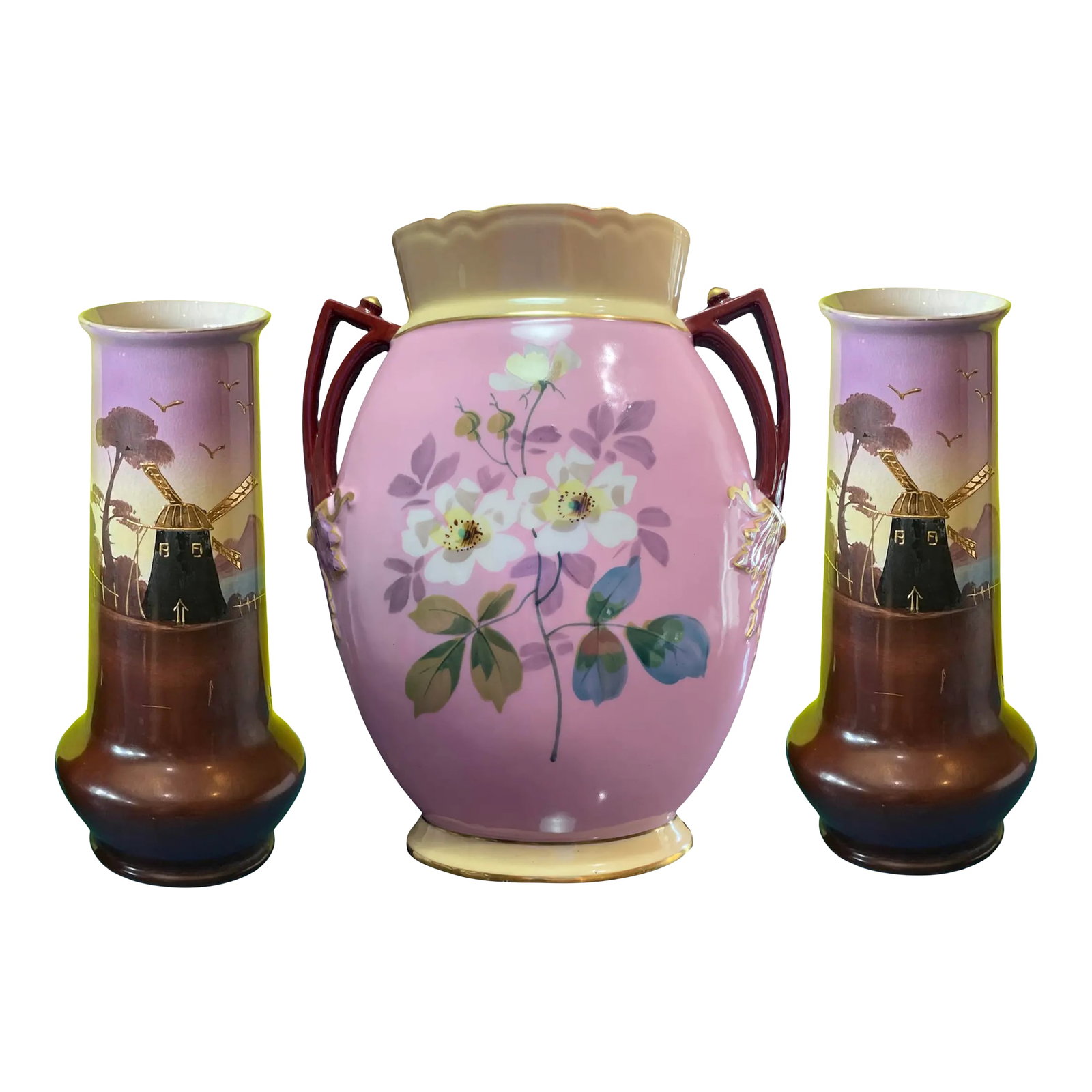Antique Porcelain Floral and Windmill Vases Set of 3: The centerpiece of this elegant trio of antique porcelain vases is a richly detailed work that captures the charm of an idyllic countryside. On one side, the central vase features a painted rural