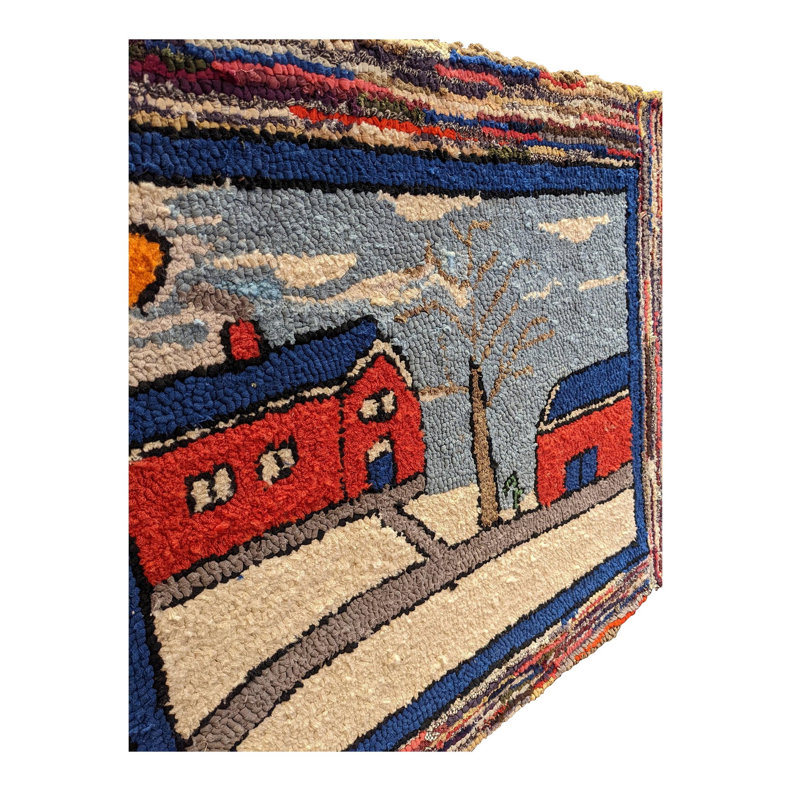 Vintage Folk Art Hand Hooked Rag Mat c.1940: A large hand-hooked folk art mat depicting a winter barn scene, dating to the 1940s. The composition features two red barns set in a snowy landscape, with a winding path, bare tree, and soft blue sky