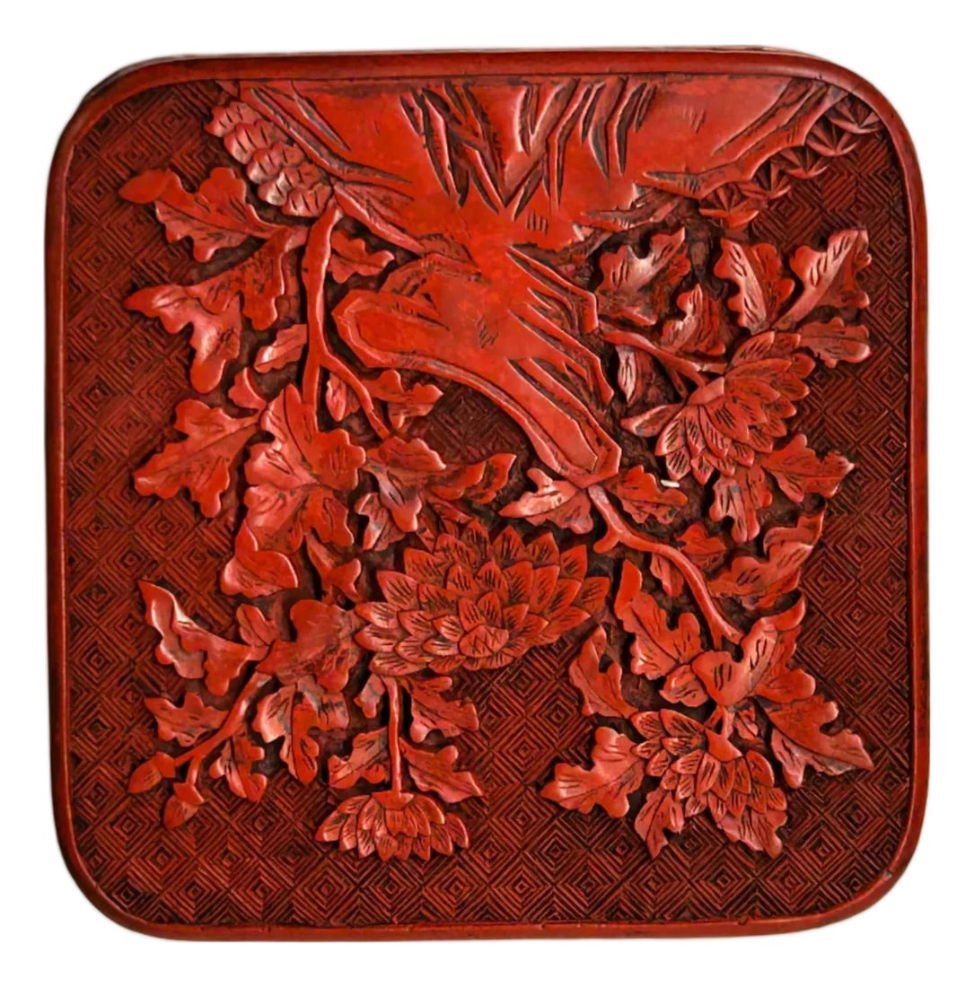 Handcrafted Vintage Chinese Red Lacquer Square Floral Accent Box: This square, deep-vermilion cinnabar lacquer box features intricate, multi-layered carvings that showcase traditional Chinese craftsmanship. The lid is dominated by a high-relief scene of