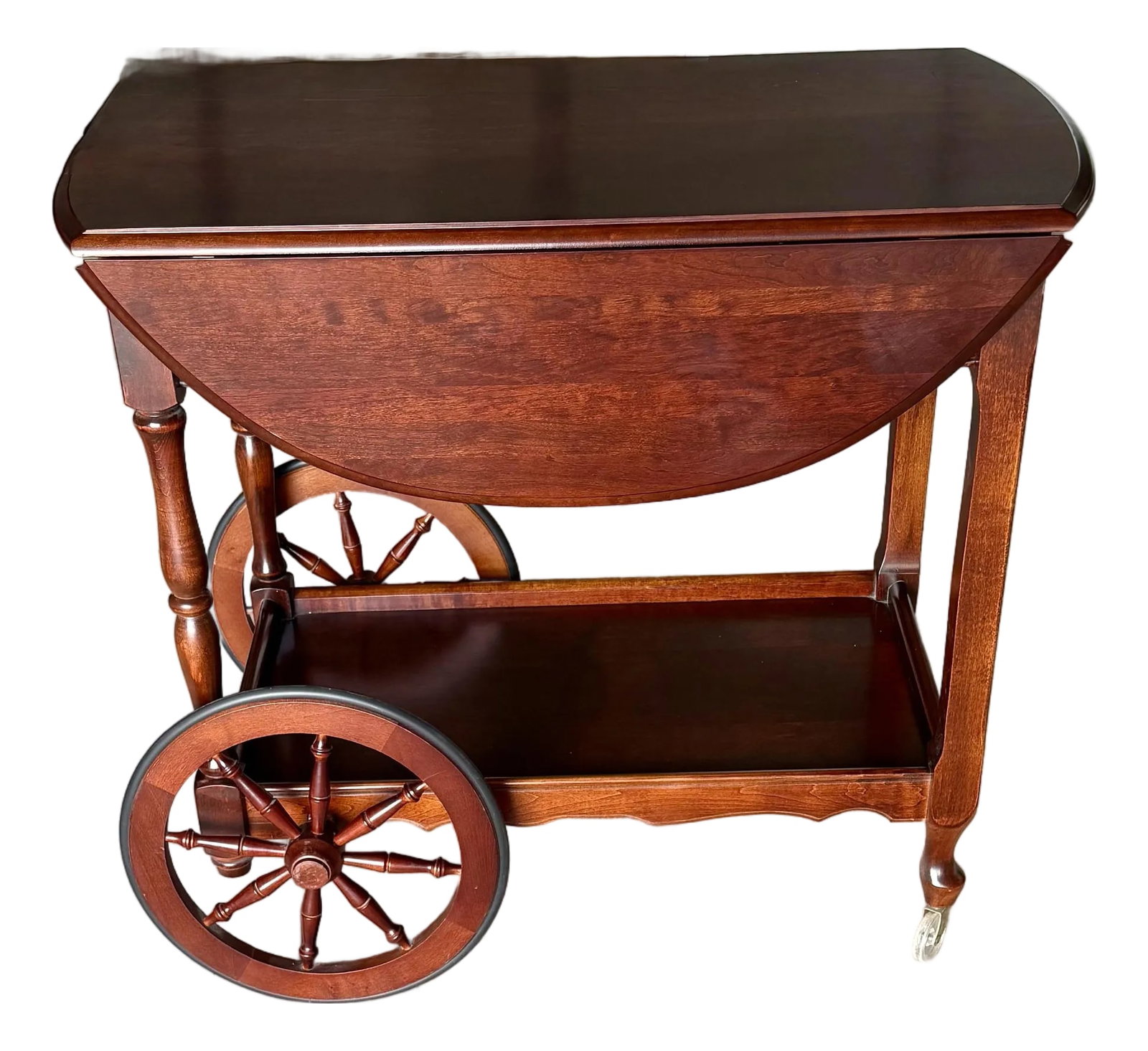 Tea Trolley With Drop Leaf Sides: This vintage Tea Trolley's construction showcases elegant craftsmanship with beautifully turned wooden posts and a spindle design on the large front wheels, reminiscent of old carriage wheels. The