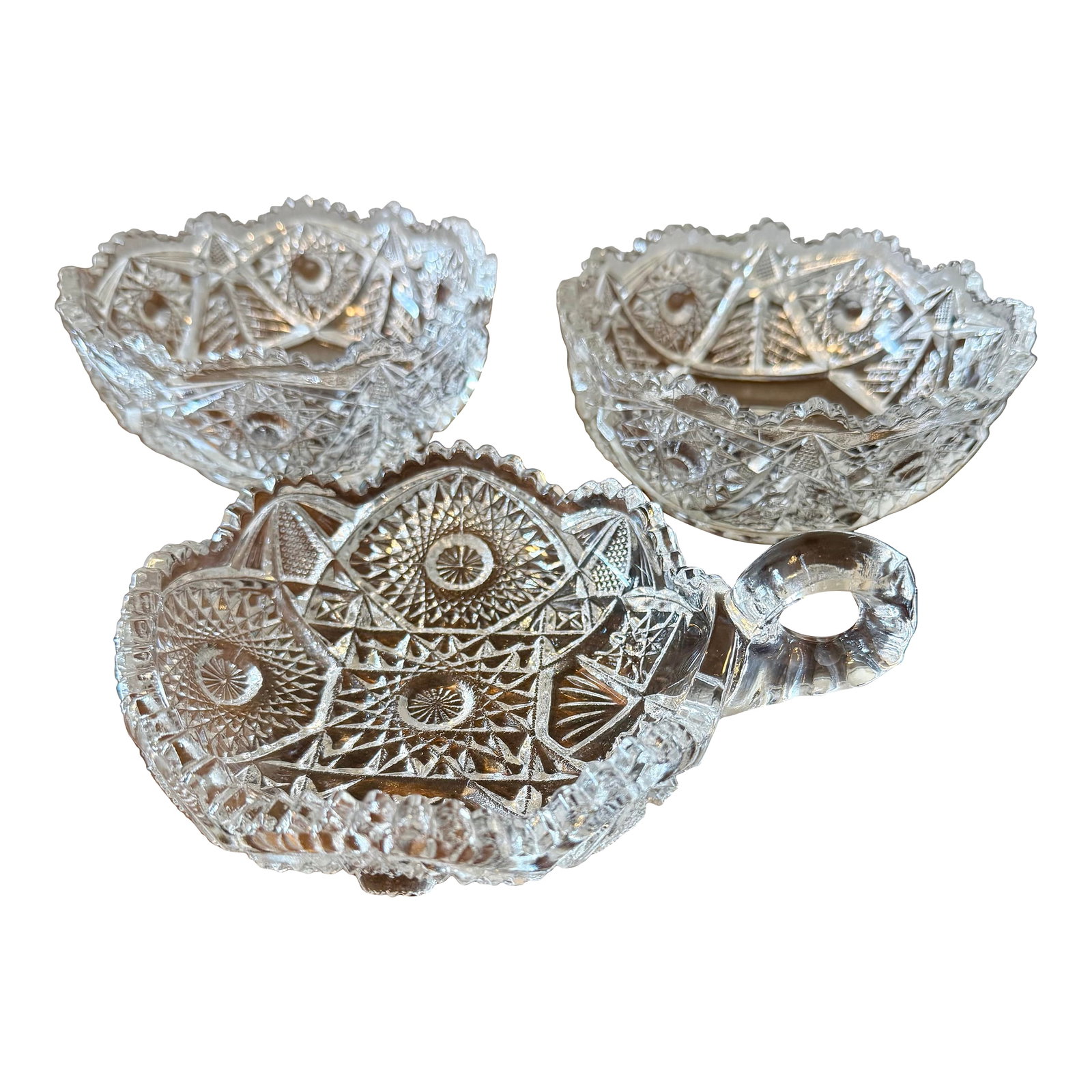 American Brilliant Nappy Bowls - Set of 3: This is a collection of three antique clear glass bowls commonly known as "˜Nappy' dishes. These small decorative bowls feature intricate geometric patterns, including stars, diamonds and fan