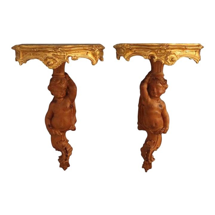 Pair of French Louis XIV Carved Figural Cherub Wood Sconces C1830: A distinguished pair of antique French Louis XIV style carved figural cherub wood sconces, dating to approximately 1830. These exquisite pieces are crafted from hand-carved wood with elegant gilt