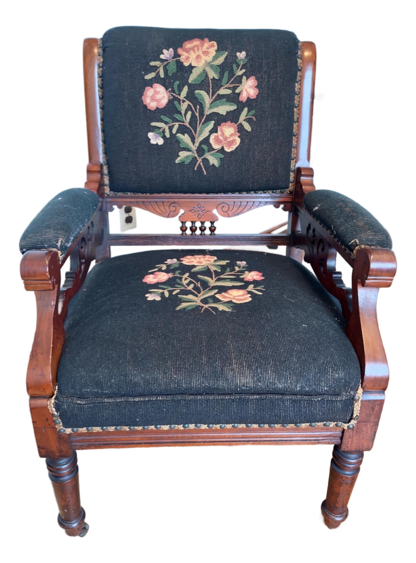 Antique Eastlake Style Victorian Needlepoint Armchair: A late Victorian period armchair featuring an emphasis on geometric lines rather than heavy curves. The chair features hand-stitched needlepoint upholstery, a delicate rose bouquet against a dark blue