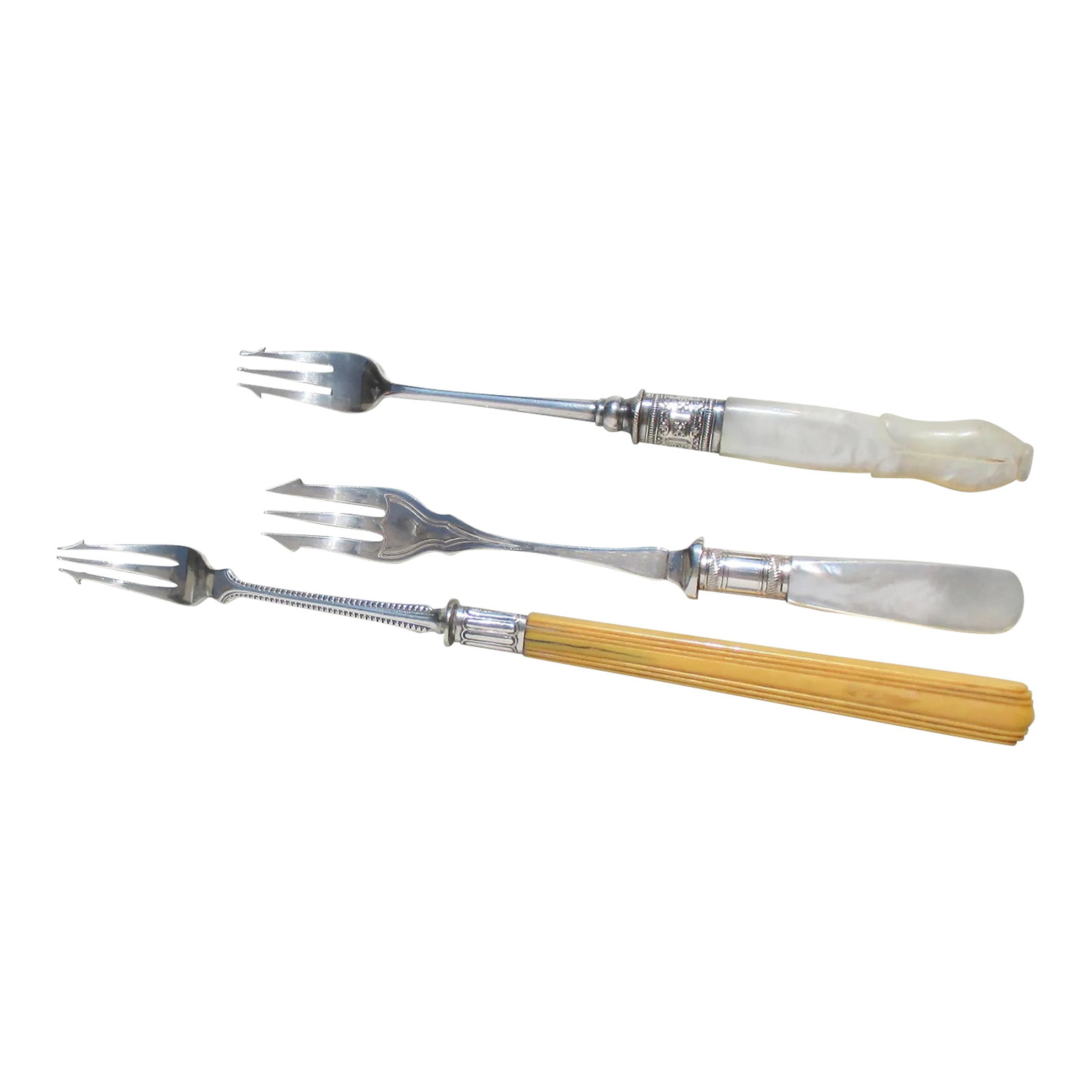 Group of Cocktail Forks - a Set of 3: A group of three fancy cocktail serving forks. Spear-tipped prongs with a celluloid handle and two mother-of-pearl handles. The group measures 8.5" long to 6.5" the shortest. Very good condition,