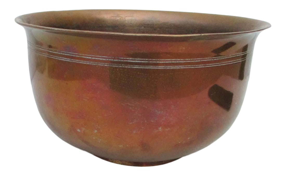Antique Early 20th Century Indian Brass and Copper Bowl: Antique Indian handmade brass bowl with copper wash. Classic form bowl with a small character on the front. Thick walls and good weight, very strong. The copper is very reflective. The size is 8.25" i