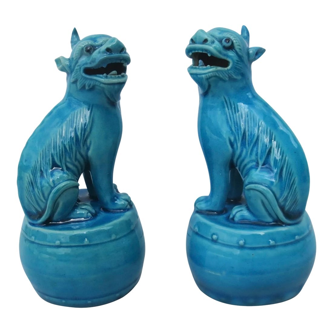 Mid 20th Century Chinese Turquoise Glazed Kylin - a Pair: Mid-20th century turquoise glazed pair of Kylin figures. Seated on drum bases with mouth open and mirrored poses. Rich turquoise glazes over all with deep blue eyes. The size is 5.6" tall and 2.6" in