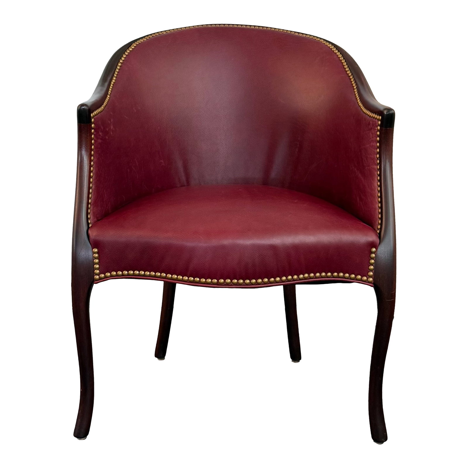 Late 20th Century Burgundy Leather Nailhead Trimmed Mahogany Library Tub Armchair: This classic library tub armchair circa the 1940s showcases a handsome barrel silhouette upholstered in a rich burgundy leather accentuated by a brass nailhead trim. It's anchored by an exposed
