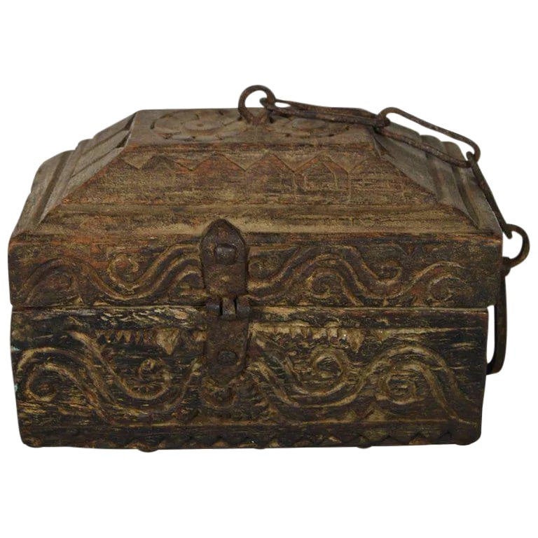 Antique Handmade Indian Carved Wood Money Box With Hardware, 19th Century: A handmade 19th century Indian money box with hardware and carved of wood. This small rectangular box displays a roof-shaped lid. Each side features carved wave and scroll patterns while the top