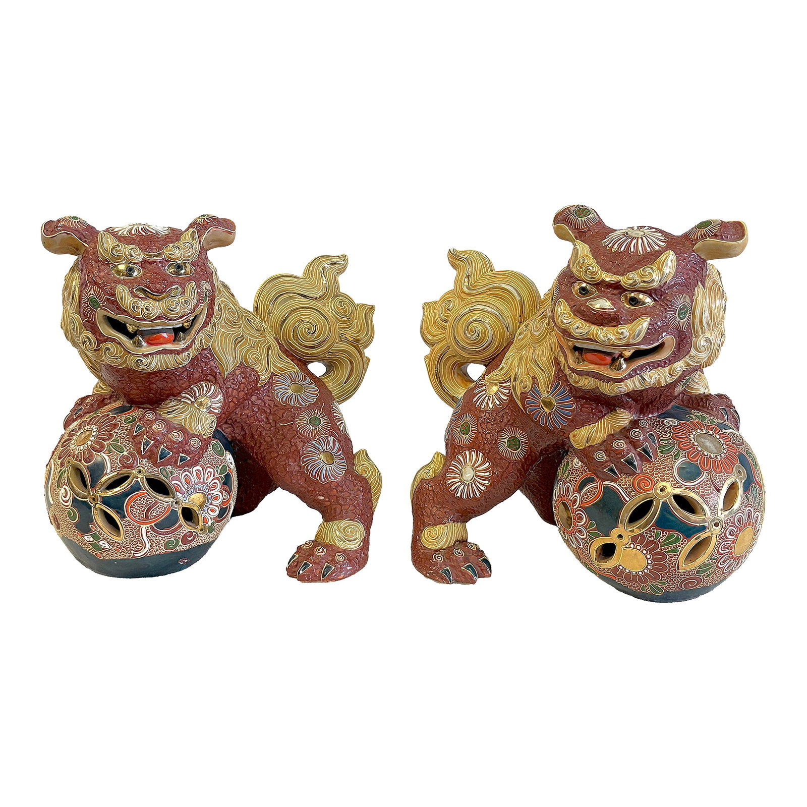 Vintage Japanese Pottery Kutani Foo Dogs in Cinnabar and Gold Colors- A Pair: Ornate pair of vintage Kutani foo dogs. The incredibly detailed pair are made of Japanese pottery with a matte finish in shades of cinnabar and yellow with bright gold accents. The mirrored pair are