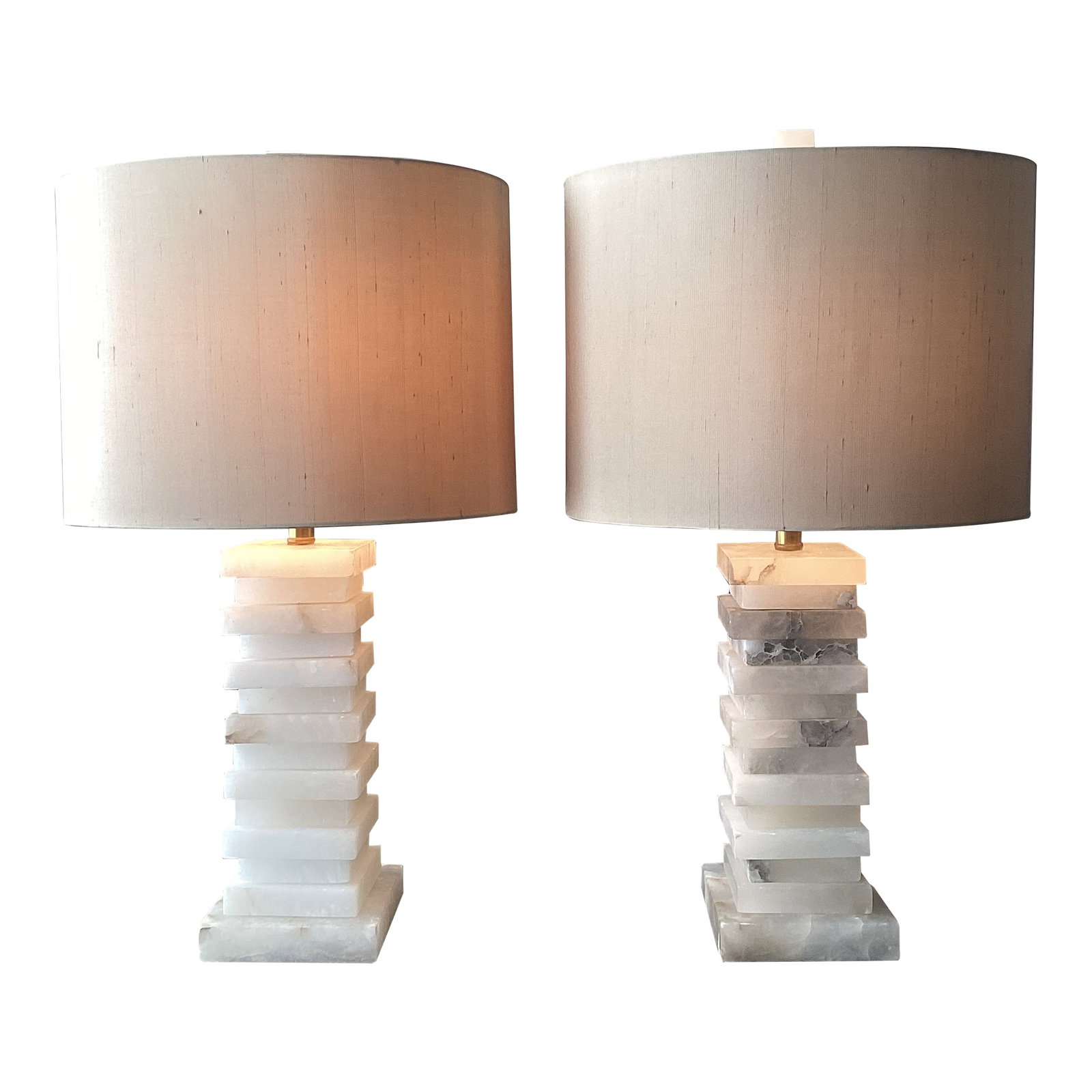 John-Richard Stacked Alabaster Column Table Lamps With Raw Silk Shades - a Pair: A striking pair of sculptural stacked alabaster table lamps by John-Richard, showcasing the brand's signature blend of natural materials and refined modern design. Each lamp features a geometric colum