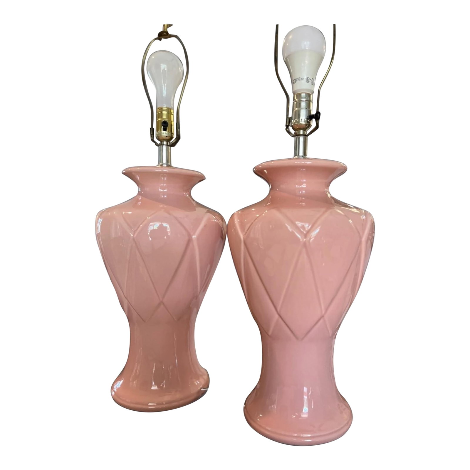 Pair of Vintage Blush Pink Ceramic Diamond Pattern Table Lamps With Three Settings/No Shades: A delightful pair of vintage ceramic table lamps featuring a glossy blush pink glaze and elegant diamond-pattern relief decoration. Their sculptural urn-form silhouettes and soft pastel color make