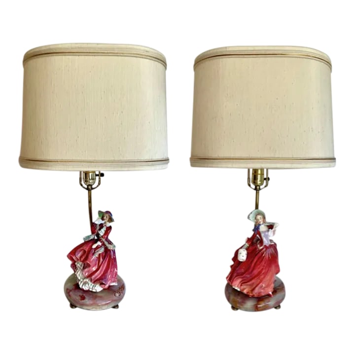 1930s Pair of English Royal Doulton Lady Figurines on Onyx Lamps: Here is a charming pair of Bone China female figurines made by Royal Doulton and mounted onto round onyx, natural stone bases. The figures appear to be from the 1930's and are in excellent condition. 