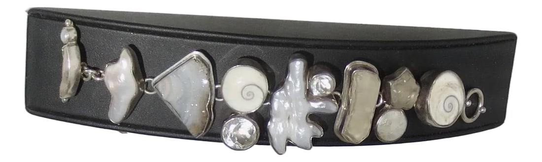 Link Bracelet Signed the Dreamer Pearl,Crystal, Geode: Fresh water Pearl, Crystal, Shell, and Geode free-formed links set in silver. Sterling mark to the back and The Dreamer. The length is 7.5" and 1.75" wide. Created in 8 sections with a ring and bar