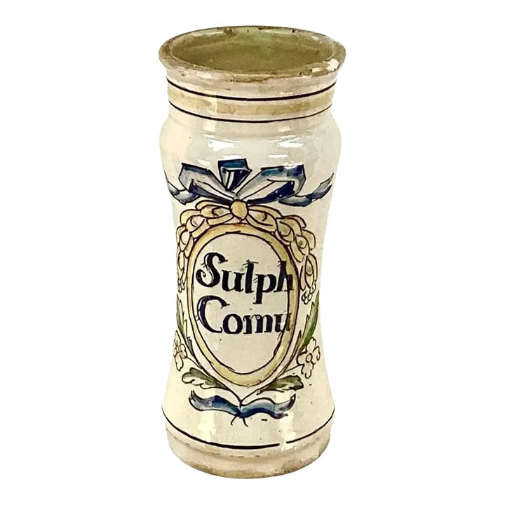 Antique 18th Century Italian Ceramic Apothecary Jar: Tall 18th century Italian ceramic apothecary jar. Has words 'Sulph Comu' on front. Floral and bow motif in colors of blue, yellow and green on off white background. Condition: Alterations: Original