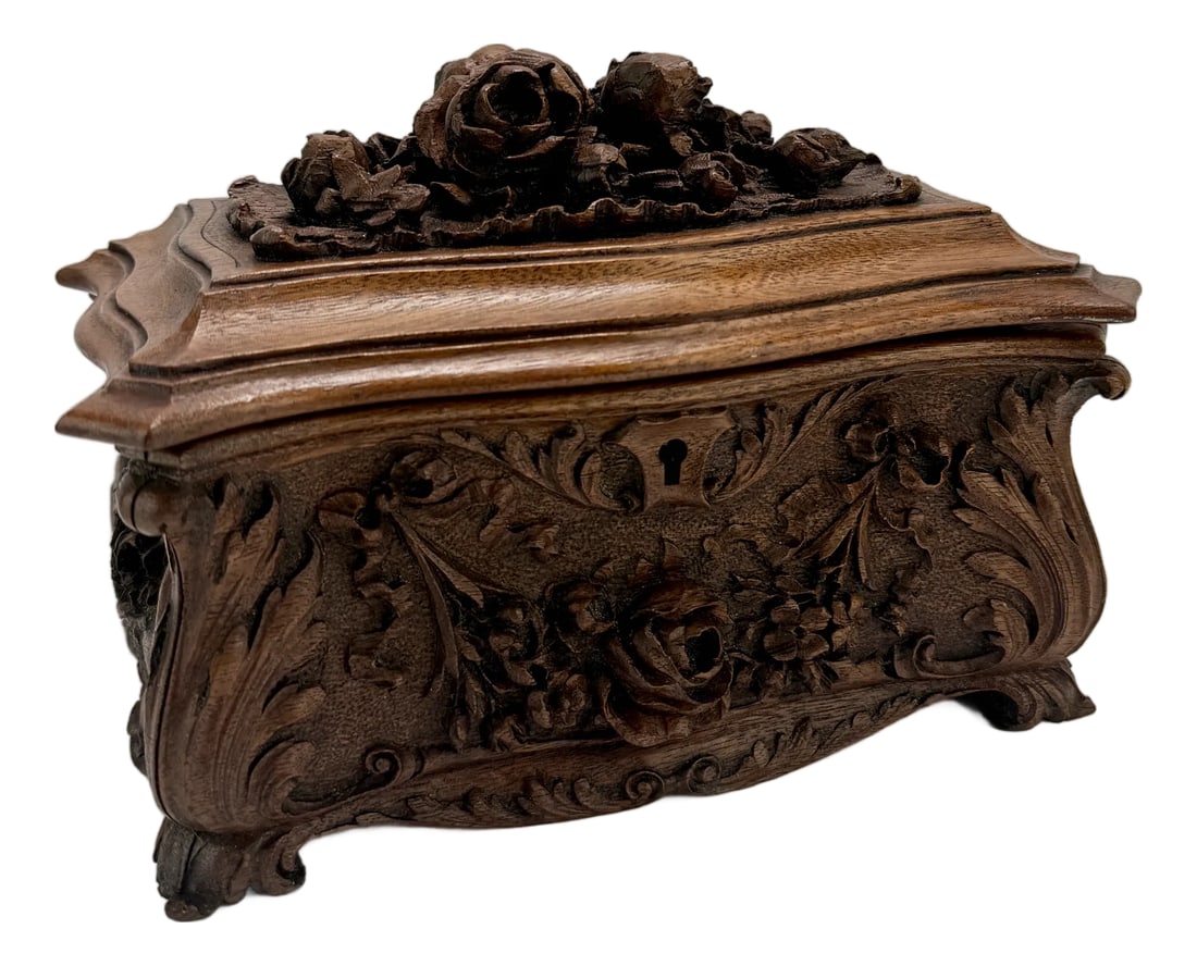 19th Century, Black Forest Carved Walnut Jewelry Casket Brienz Region: A finely carved 19th-century Black Forest walnut jewelry casket, attributed to the Brienz region of Switzerland, distinguished by its lavishly naturalistic ornamentation and sculptural detailing. The
