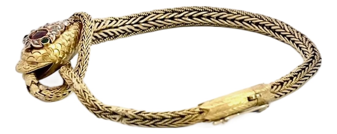 Late 19th Century 14k Yellow Gold Snake Bracelet: This captivating serpent bracelet is crafted in rich yellow gold, featuring a finely woven herringbone-pattern chain that coils elegantly around the wrist. The articulated snake's head is rendered in