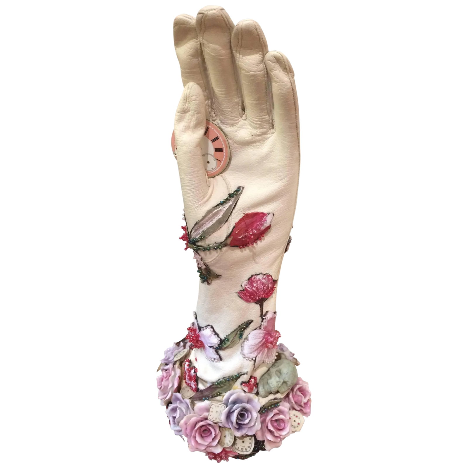 Romantic Mixed-Media Sculpture Titled Hand of Time: Mixed-media thoughtful assemblage sculpture of a leather gloved hand embellished with porcelain flowers, floral beaded adornments, and skull,...provocatively holding a pink clock face suggesting the