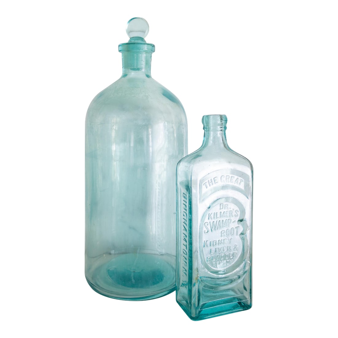 Pair of Antique Aqua Glass Medical Snake Oil Apothecary Bottles From Ny and Nj: This set of antique apothecary bottles is paired for their matching deep aqua color. A large cylindrical, two-liter bottle with a glass stopper is hand-etched with the one and two-liter measurements.