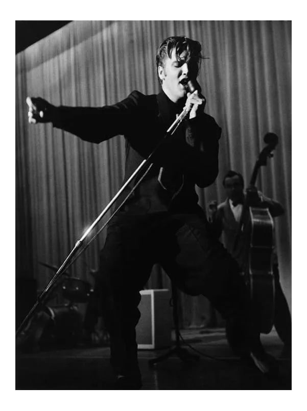 Elvis Presley 1956: Elvis Presley performing in Los Angeles, 1956. Photo by Ernest Reshovsky. 11" x 14" silver gelatin print. Printed later under the direct supervision of Sid Avery and signed on verso by Sid Avery. #