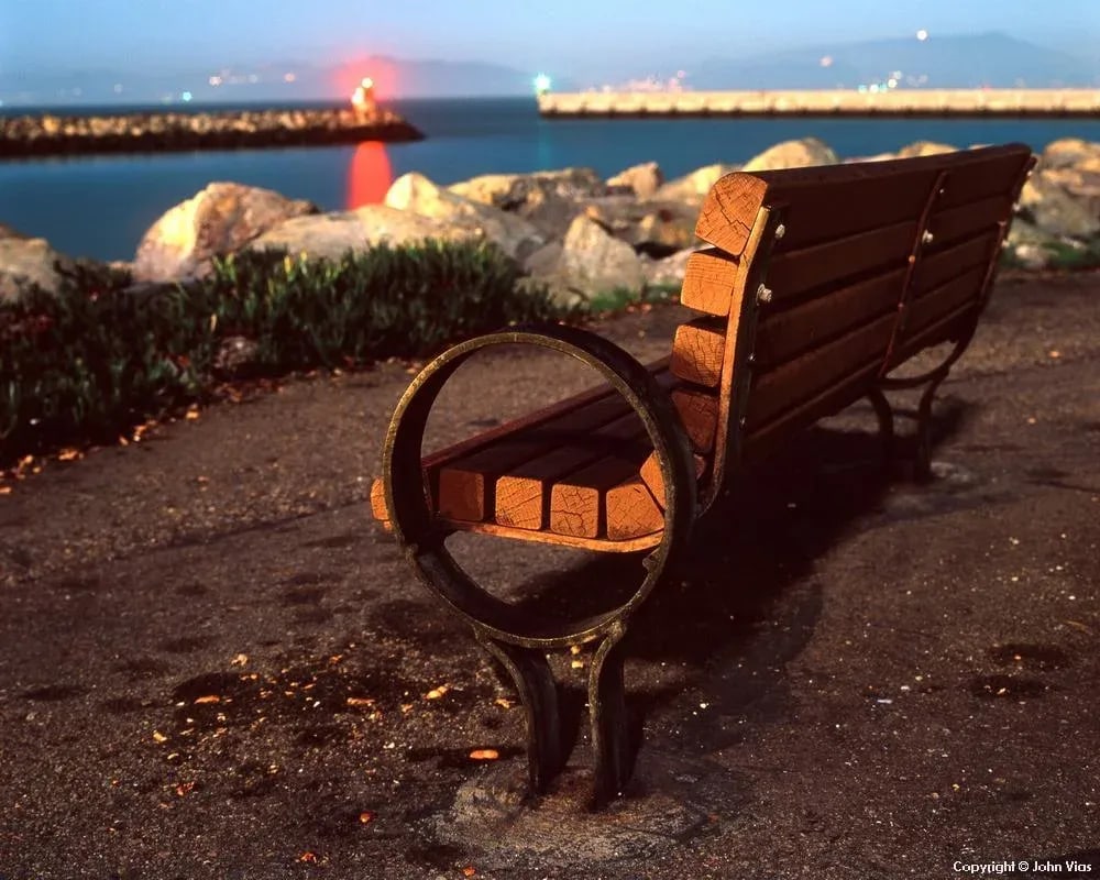 Contemporary Night Photograph "Edge-On Bench" by John Vias: Note from the artist, John Vias: "It was a damp, cold night. Lens fogging ultimately cut short my photography expedition." This 11" x 14" archival color photograph is presented in a 16" x 20"