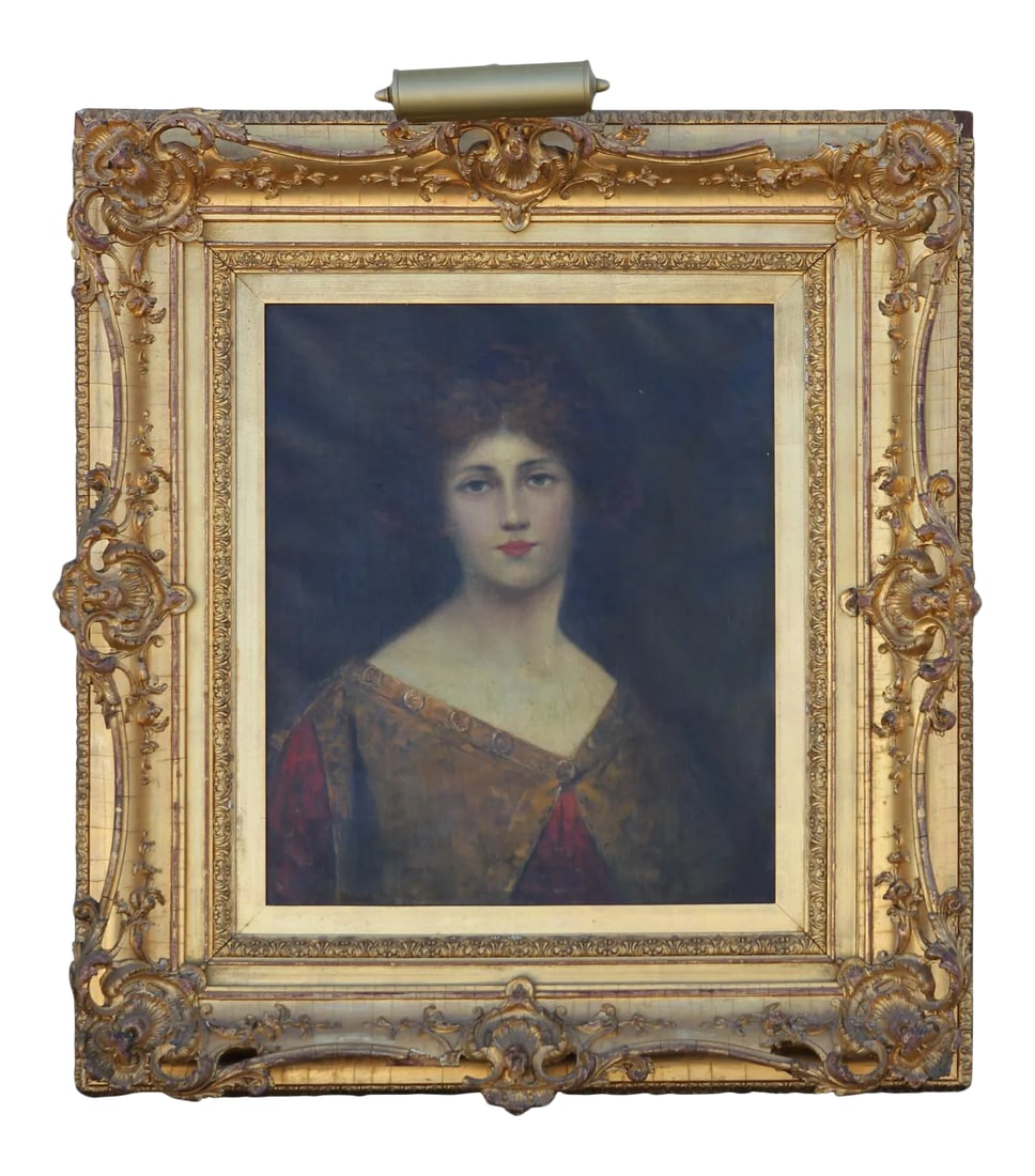 Unknown Early Portrait of a Young Woman 1900's: Elegant portrait painting of a young woman with red hair. The painting is framed in a decorative gold frame with a light attached to the top. The piece is signed by the artist in the bottom corner.