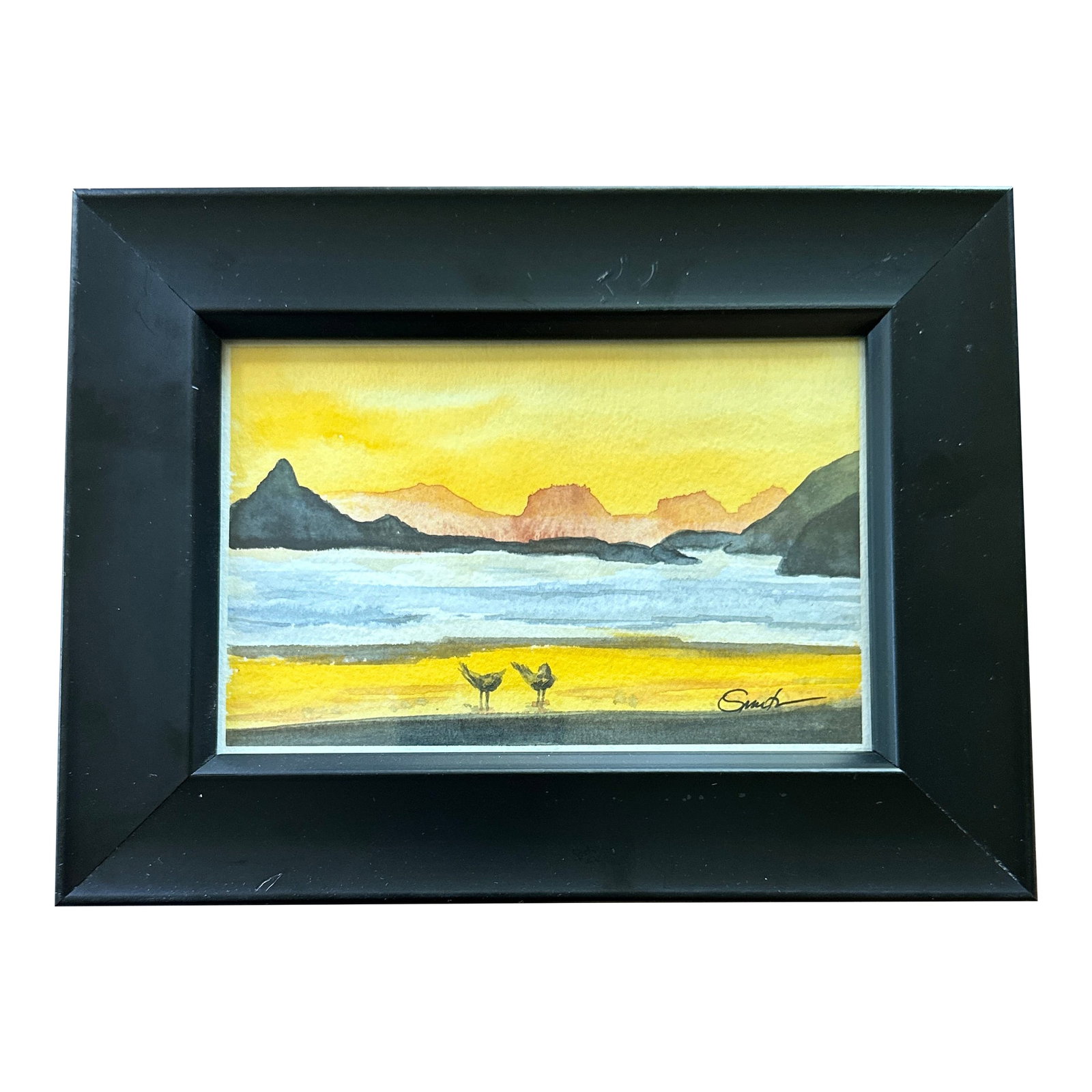 "Golden Hour Stroll" Framed Signed Original Watercolor Painting by Nancy Smith: Set against the serene backdrop of a golden sunset, "Golden Hour Stroll" features two small shorebirds exploring a quiet beach as distant mountains fade into soft hues. This tranquil watercolor radiat
