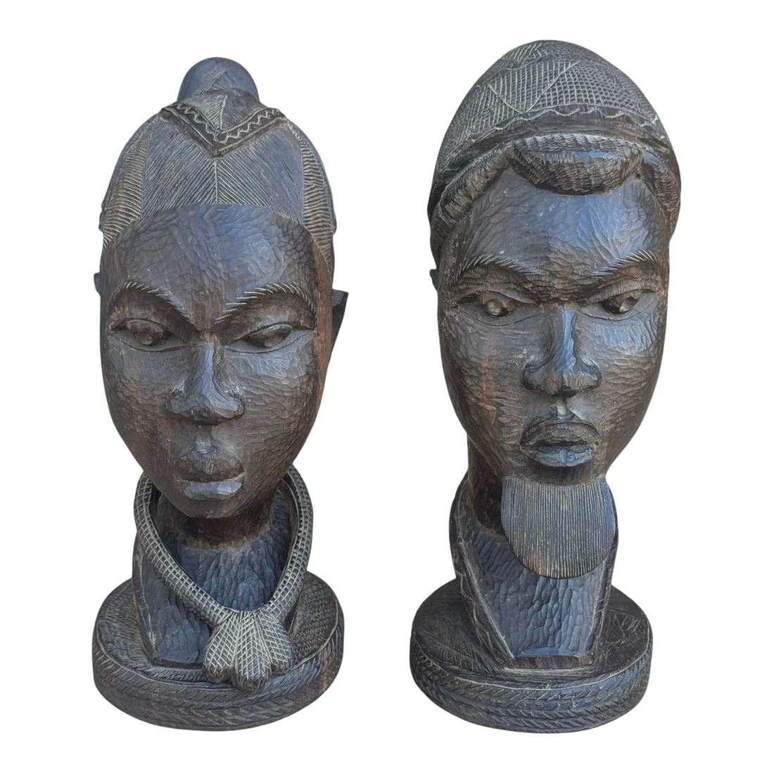 Pair of Mid 20th Century Male & Female Nigerian Busts Hand Carved in Ebony Wood: A beautiful pair of hand carved busts of a Nigerian woman & man. Amazing details in ebony wood. The woman's necklace was carved out of the original block of wood and moves fully around her neck. Each