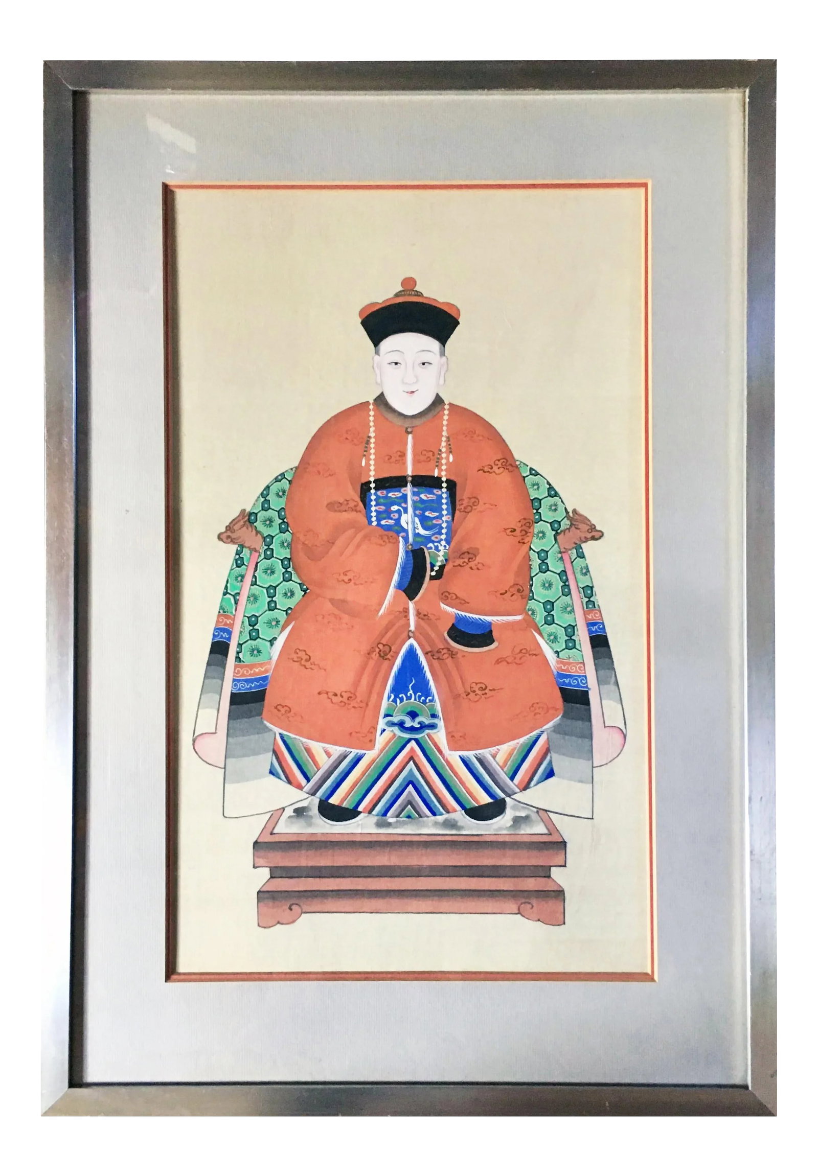 Antique Chinese Ancestor Portrait in Silver Leaf Frame: A vibrant and colorful Chinese seated ancestor portrait depicting a patriarch of 7th-rank official status. He is seated wearing a beautifully decorated geometric and patterned robe and hat. Mounted in