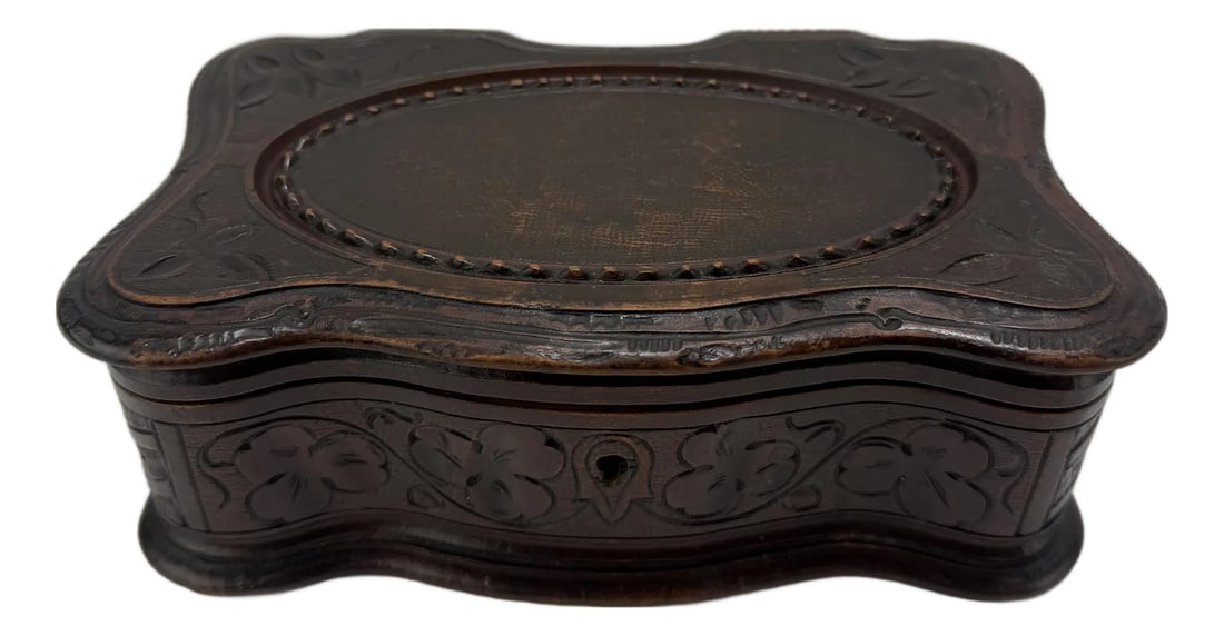 Mid-19th Century Carved Walnut Jewelry or Trinket Box, Likely Black Forest: A finely carved walnut jewelry or trinket box, mid-19th century, likely of Black Forest or Swiss origin. The serpentine rectangular form exhibits a curvilinear Rococo outline with scalloped edges, the