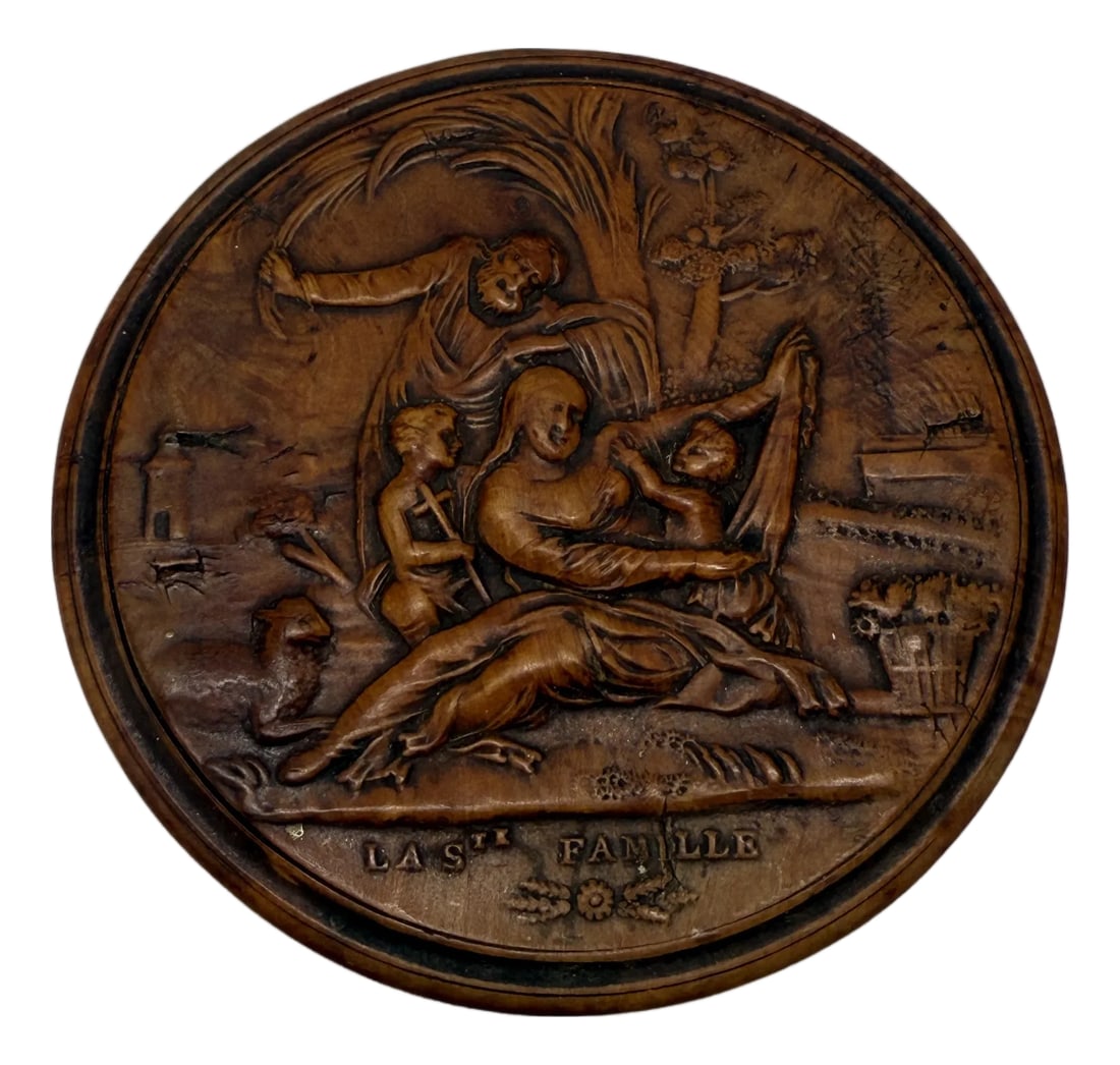 Early 19th Century French Carved Boxwood Snuff Box, "La Ste Famille": A finely carved circular snuff box in boxwood, French, circa 1820, the lid delicately rendered in relief with a devotional scene inscribed "LA STE FAMILLE" (The Holy Family). The carving depicts the