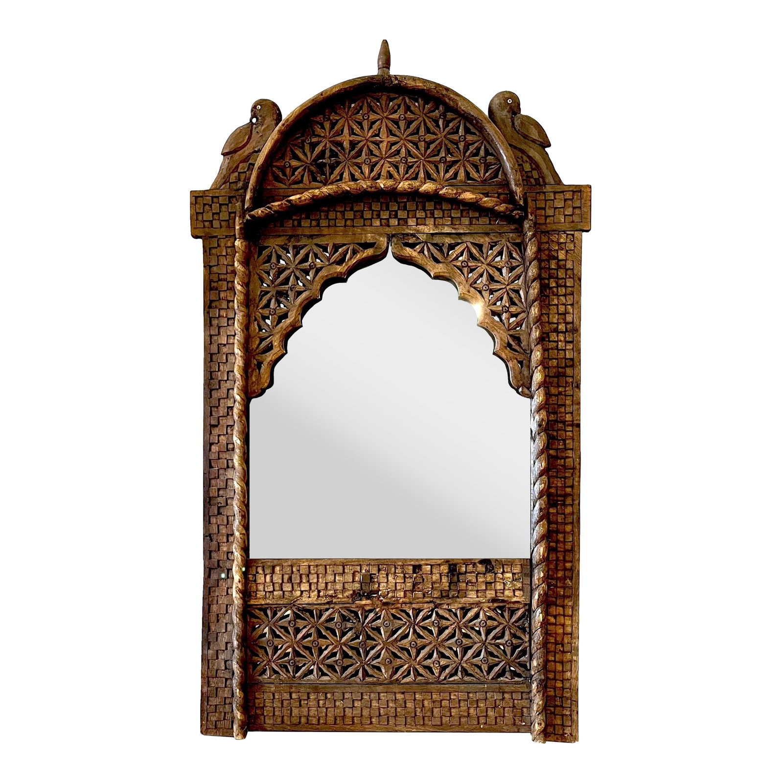 Late 20th Century Moorish Boho Chic Hand-Carved Wooden Wall Mirror: This intricately hand-carved wooden wall mirror makes an exotic "boho" statement. Features a moorish arch topped with two bird finials. Key elements also include pierced ethnic patterned panels,