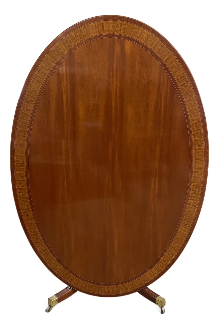 Large Oval Mahogany Tilt-Top Table: A wonderful and unusually large oval tilt-top table with a satinwood inlaid Greek Key border. This is perfect for an extra dining table that can be folded down when needed! Made in England by Bevan