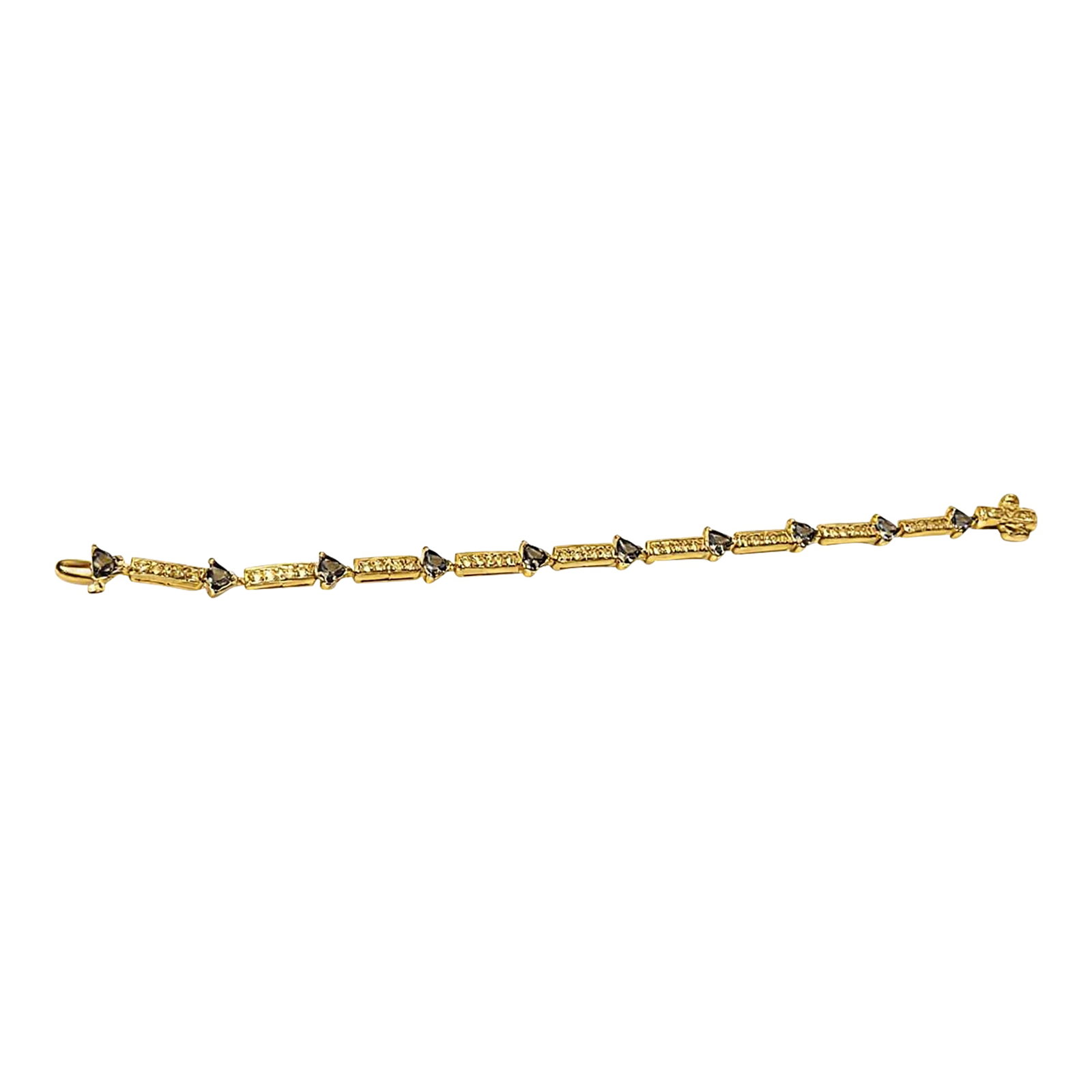 14k Gold Trillion Cut Tanzanite Diamond Tennis Bracelet: An elegant 14K yellow gold tennis bracelet featuring natural trillion-cut tanzanites accented by diamond-set links. The distinctive geometric shape of the tanzanites creates a sophisticated and