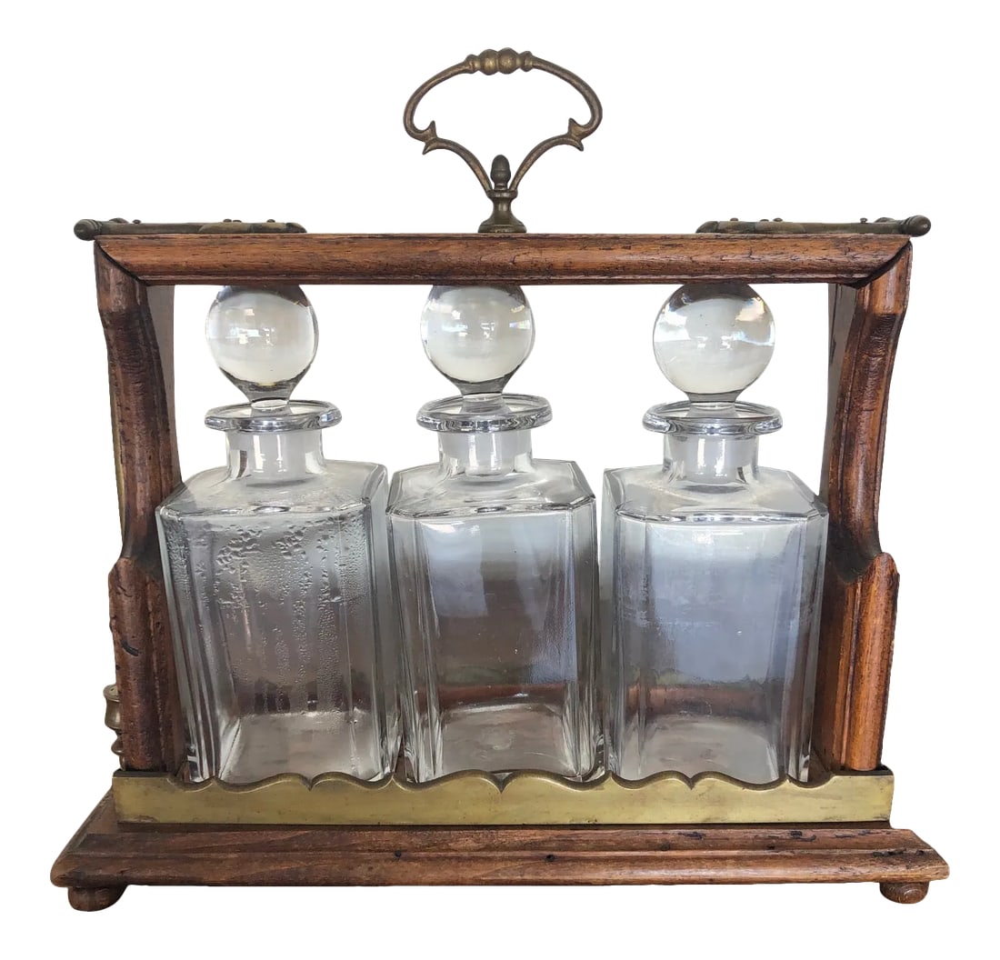 Antique English Oak Decanter Tantalus: A very special three bottle crystal decanter tantalus executed with brass mounts on an oak platform. The latch mechanism functions as intended, and it has its original unusual cylinder brass lock and 