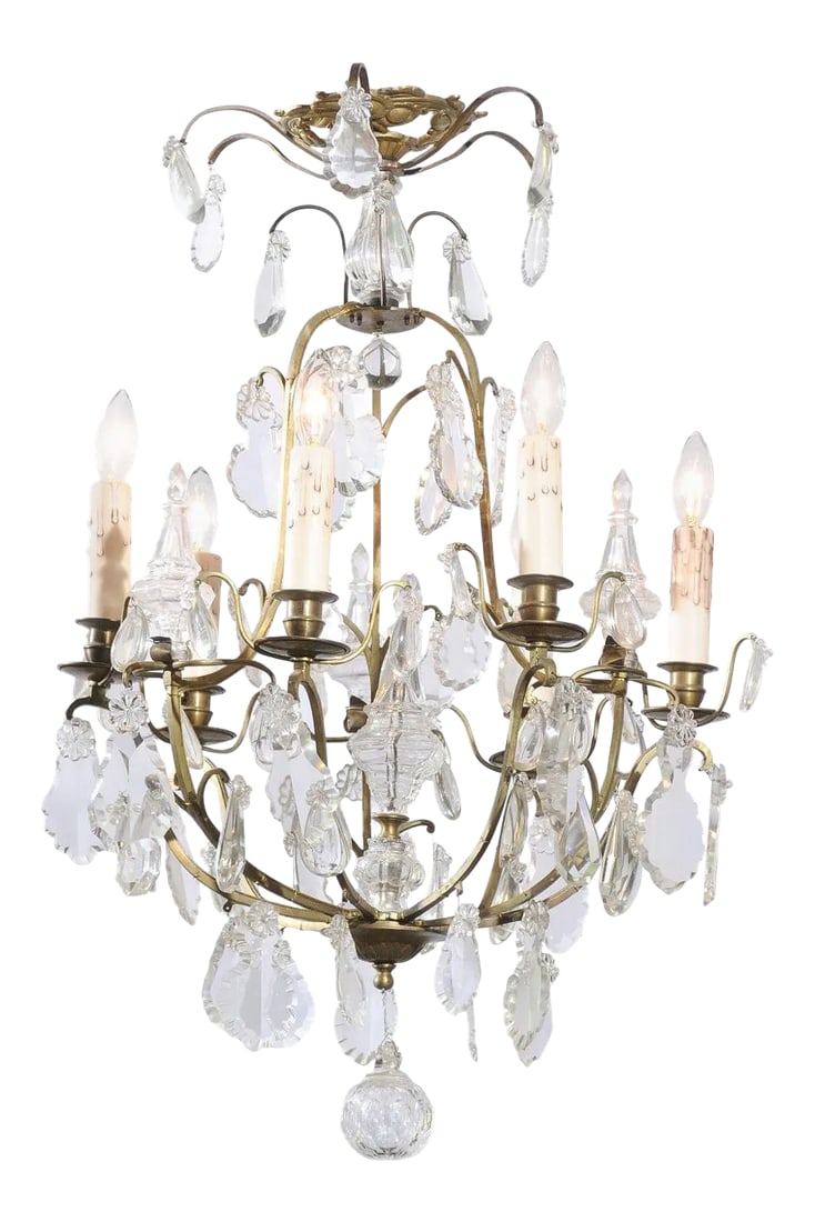 French 19th Century Six-Light Crystal Chandelier with Scrolled Brass Armature: A French six-light crystal chandelier from the 19th century, with brass armature, pendeloques and round finial. Born in France during the politically dynamic 19th century, this lovely six-light