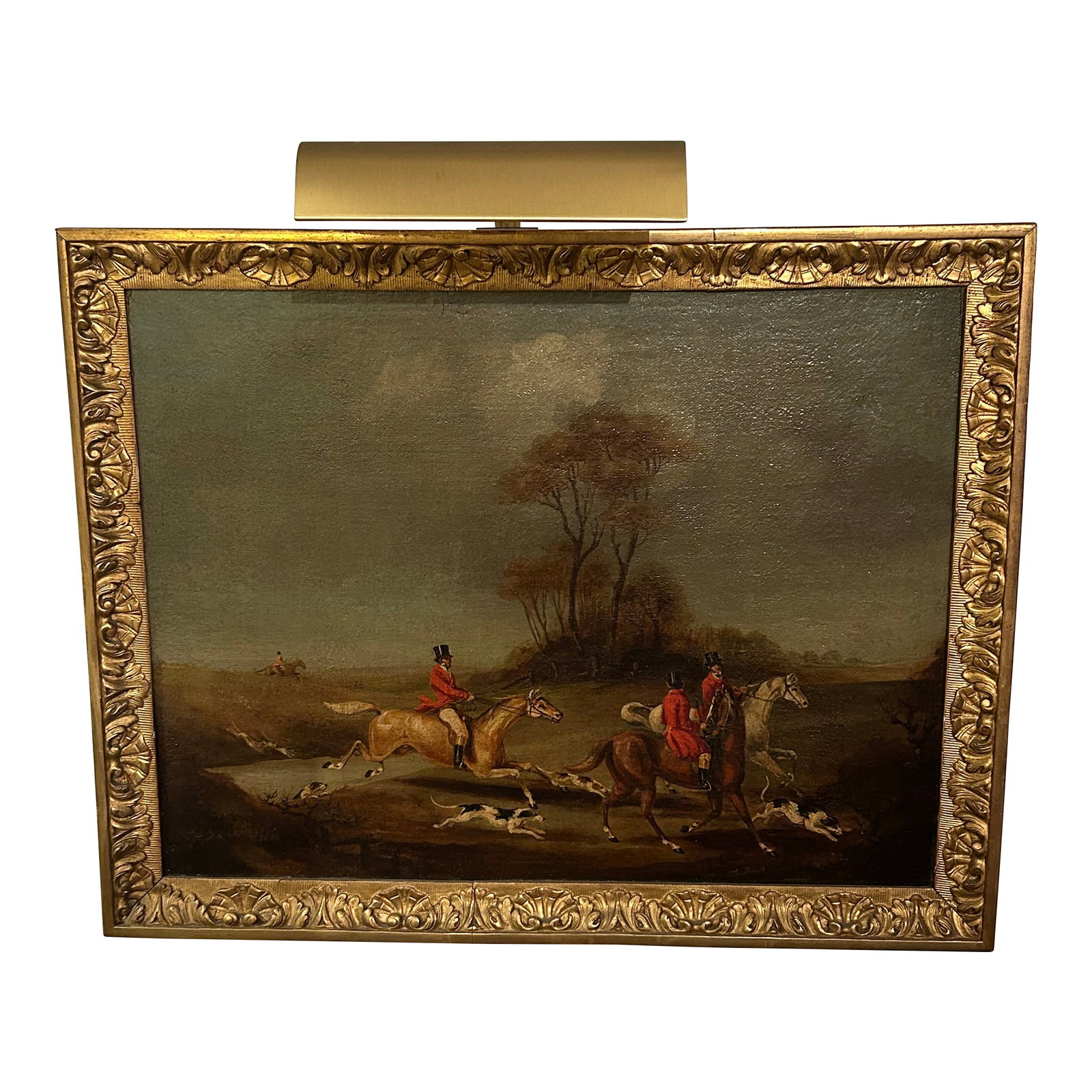 Vintage Hunt Scene Paintings - A Pair: Richly rendered vintage pair of detailed hunt scenes in a classic style, having men in red period jackets, white horses and handsome hounds. Framed beautifully and with attached brass lights on top.