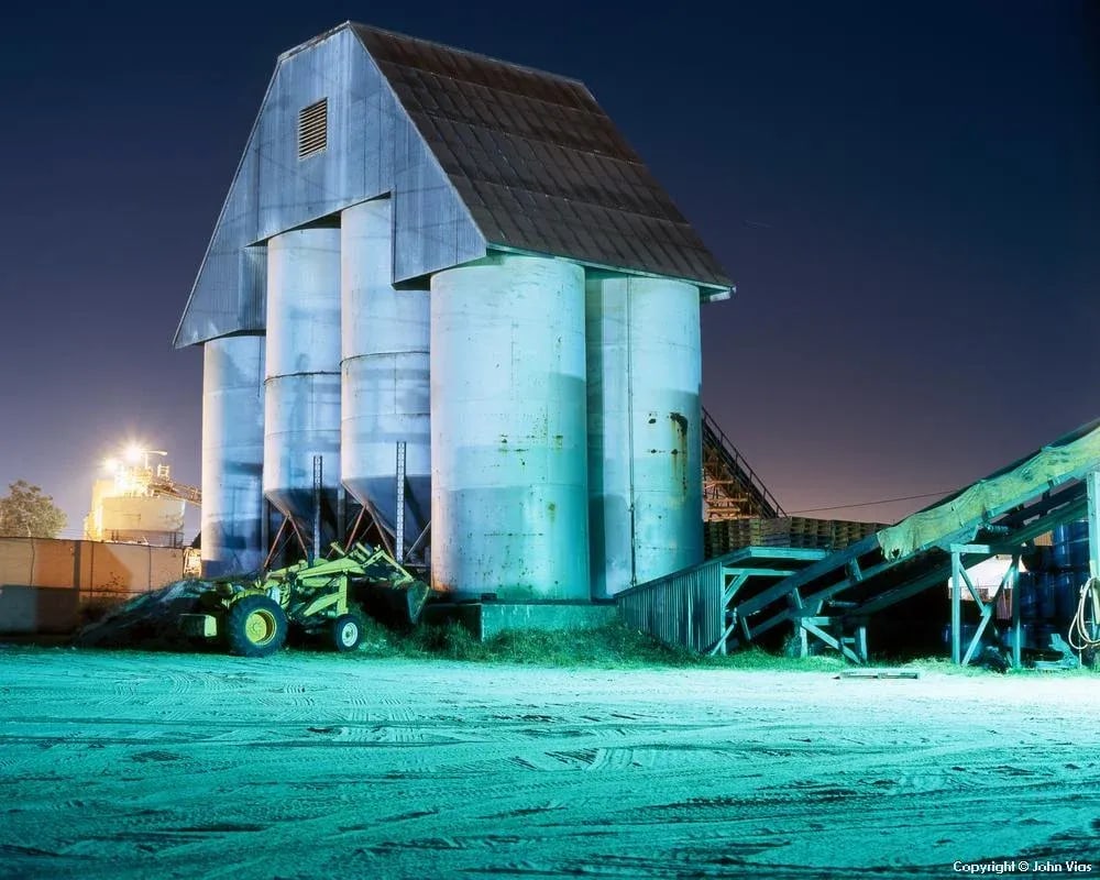 Contemporary Night Photograph "Silos" by John Vias: Note from the artist, John Vias: "These are the same silos that are in one of my earlier images. I am repeatedly reminded how the same subject can put on a new face in a new photo." This 8" x 10"